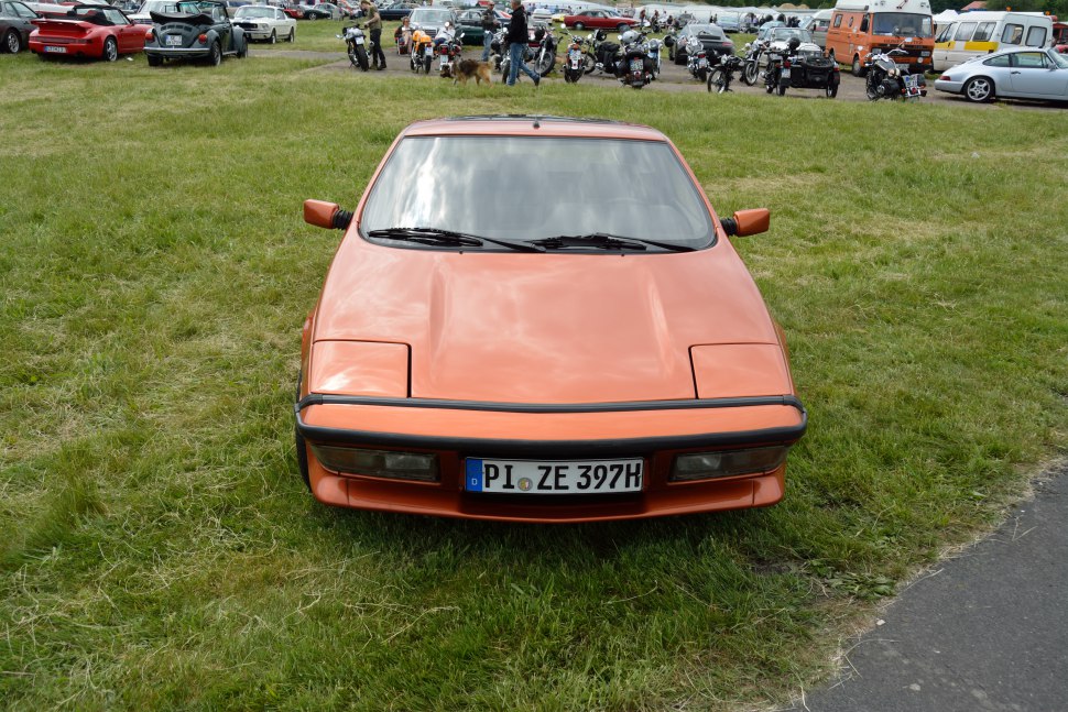 Front view of vintage sports vehicle with pop-up headlights and angular body.