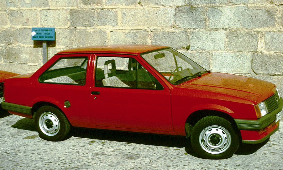 Red 2-door boxy sedan with steel wheels