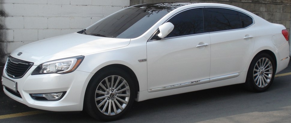 Side front view of white sedan with tinted windows and alloy wheels