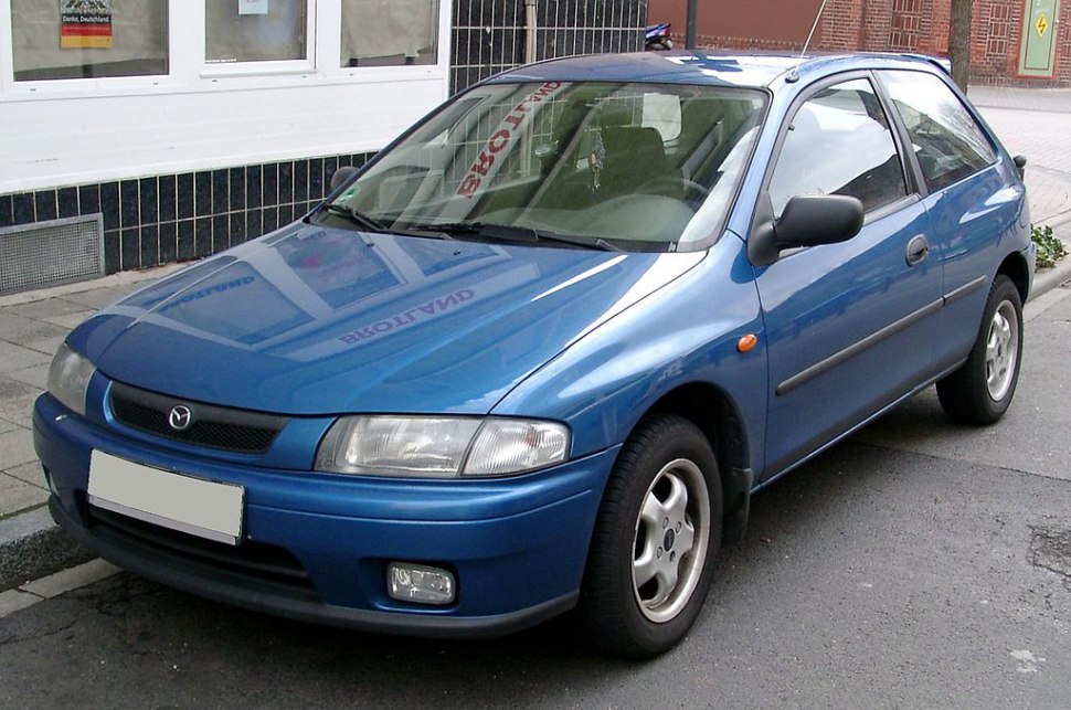 Compact blue hatchback front-side view with fog lights