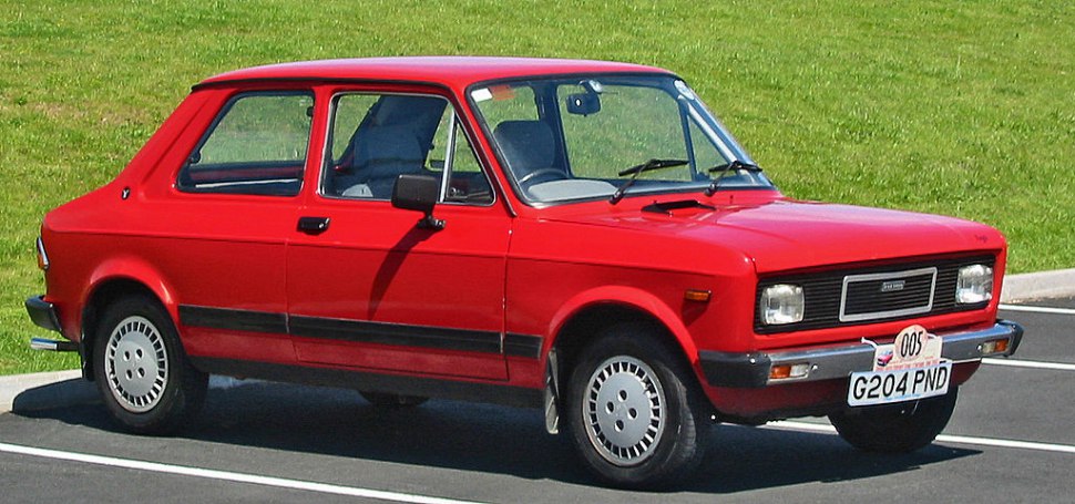 Red compact vintage car with boxy design and classic styling