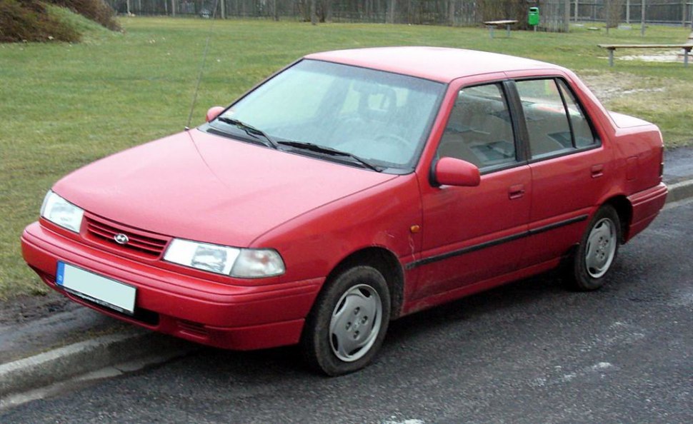 Red compact four-door sedan front three-quarter view