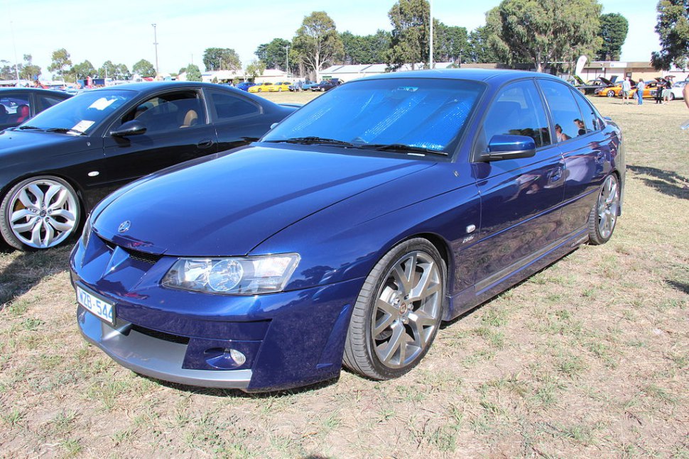 Blue sports sedan with front-side angle and alloy wheels.