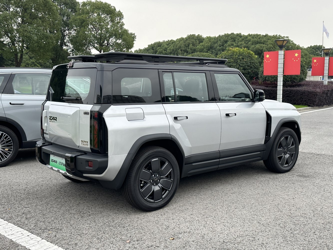 Rear-side view of modern SUV with roof rails and black rims