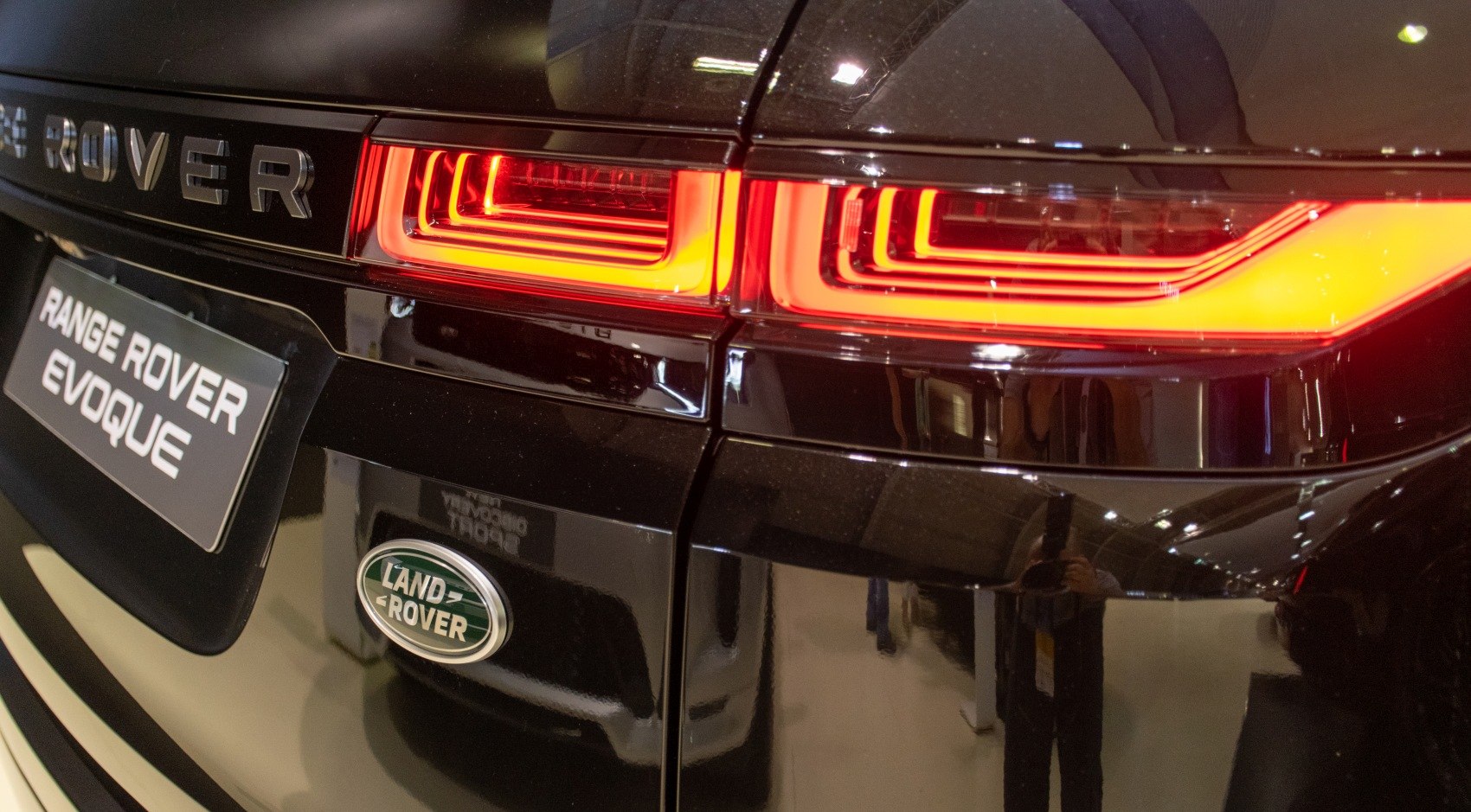 Rear LED tail lights and Land Rover badge on black car body