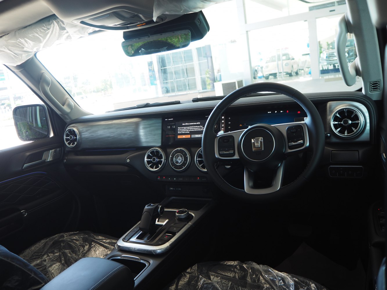 Dashboard and steering wheel with digital displays and round vents