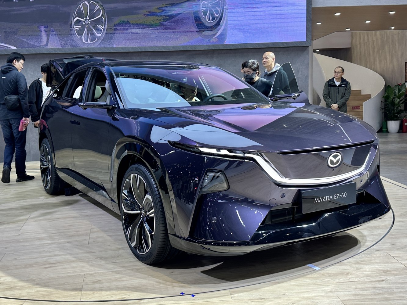 Front view of a sleek electric SUV with distinctive LED headlights and modern wheels