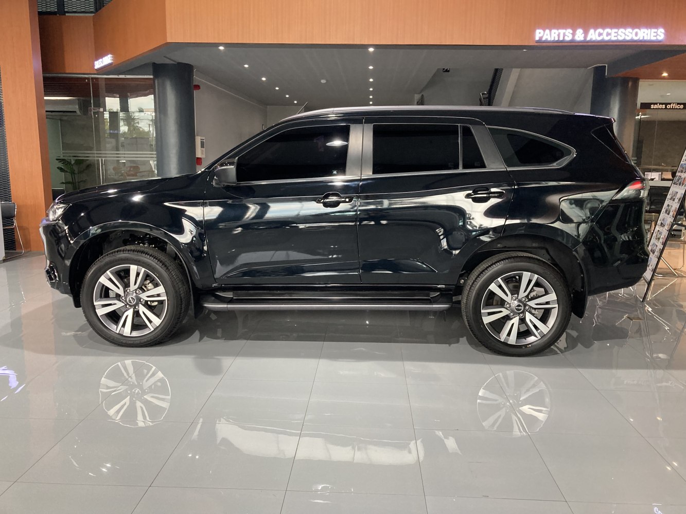 Side profile of a black SUV with tinted windows and alloy wheels