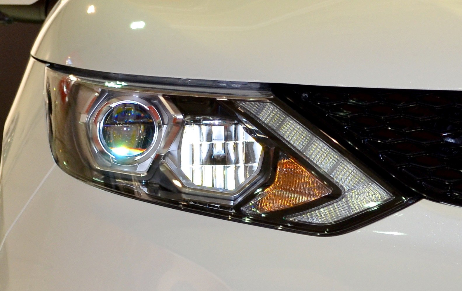 Close-up of Nissan Qashqai II J11 headlight with LED and projector elements