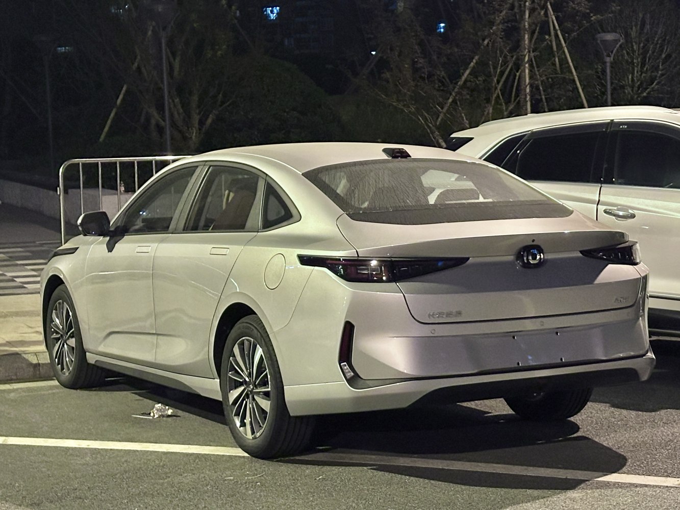 Sleek aerodynamic rear with continuous dark tinted rear lights and alloy wheels.