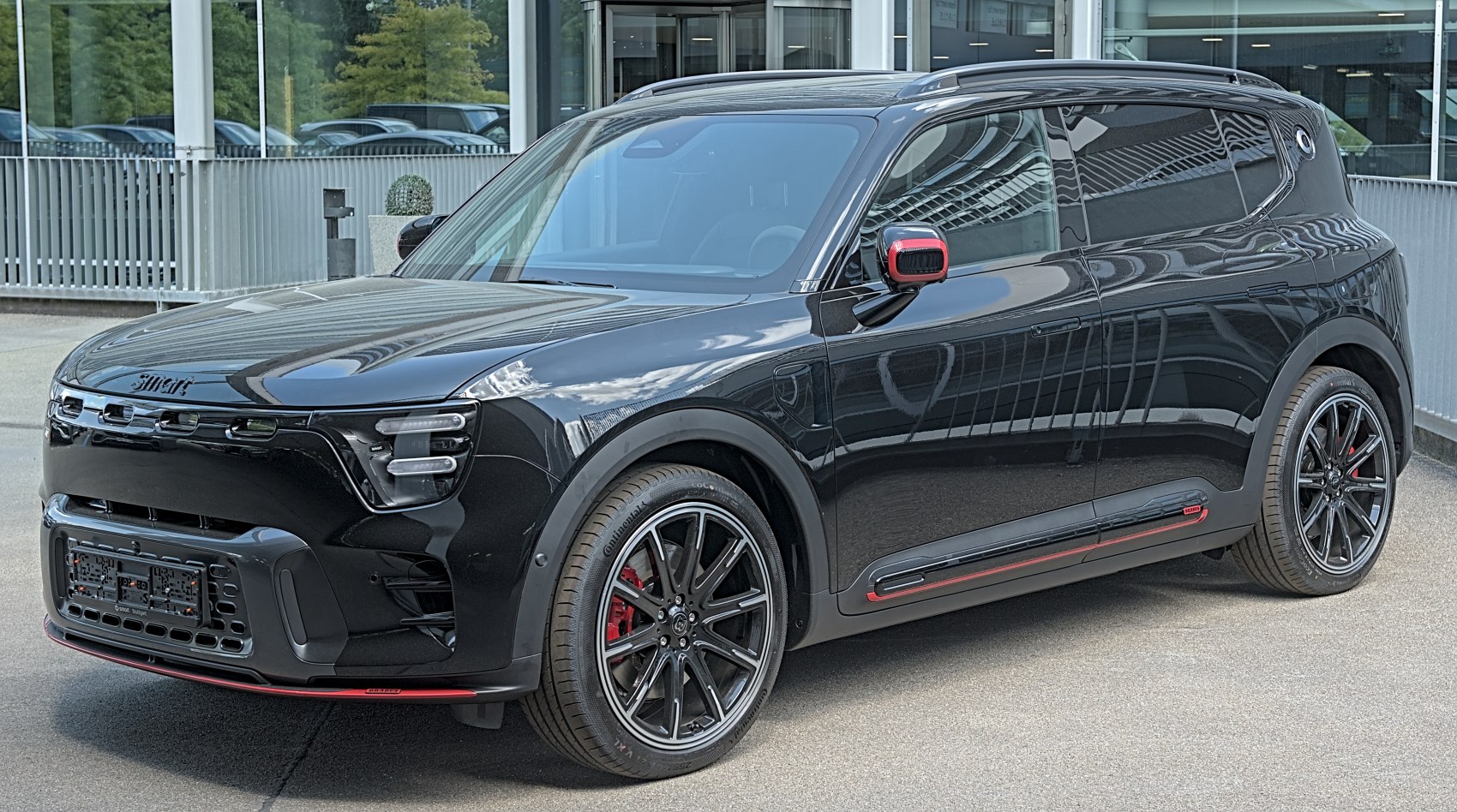 Glossy black electric compact SUV with red accents and sporty wheels