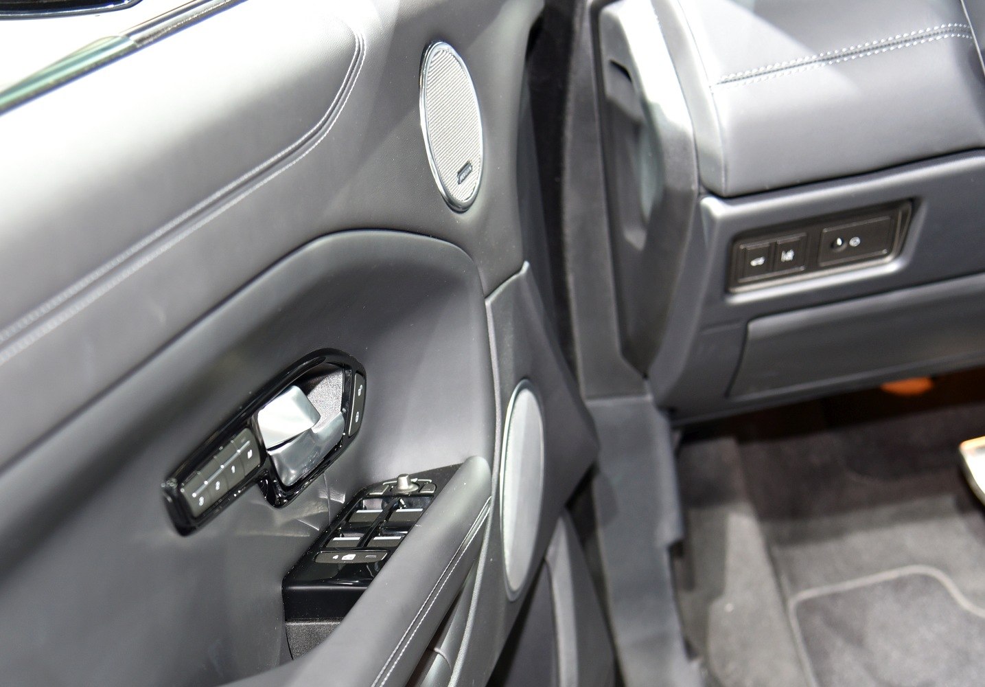 Interior door panel with window controls and speaker