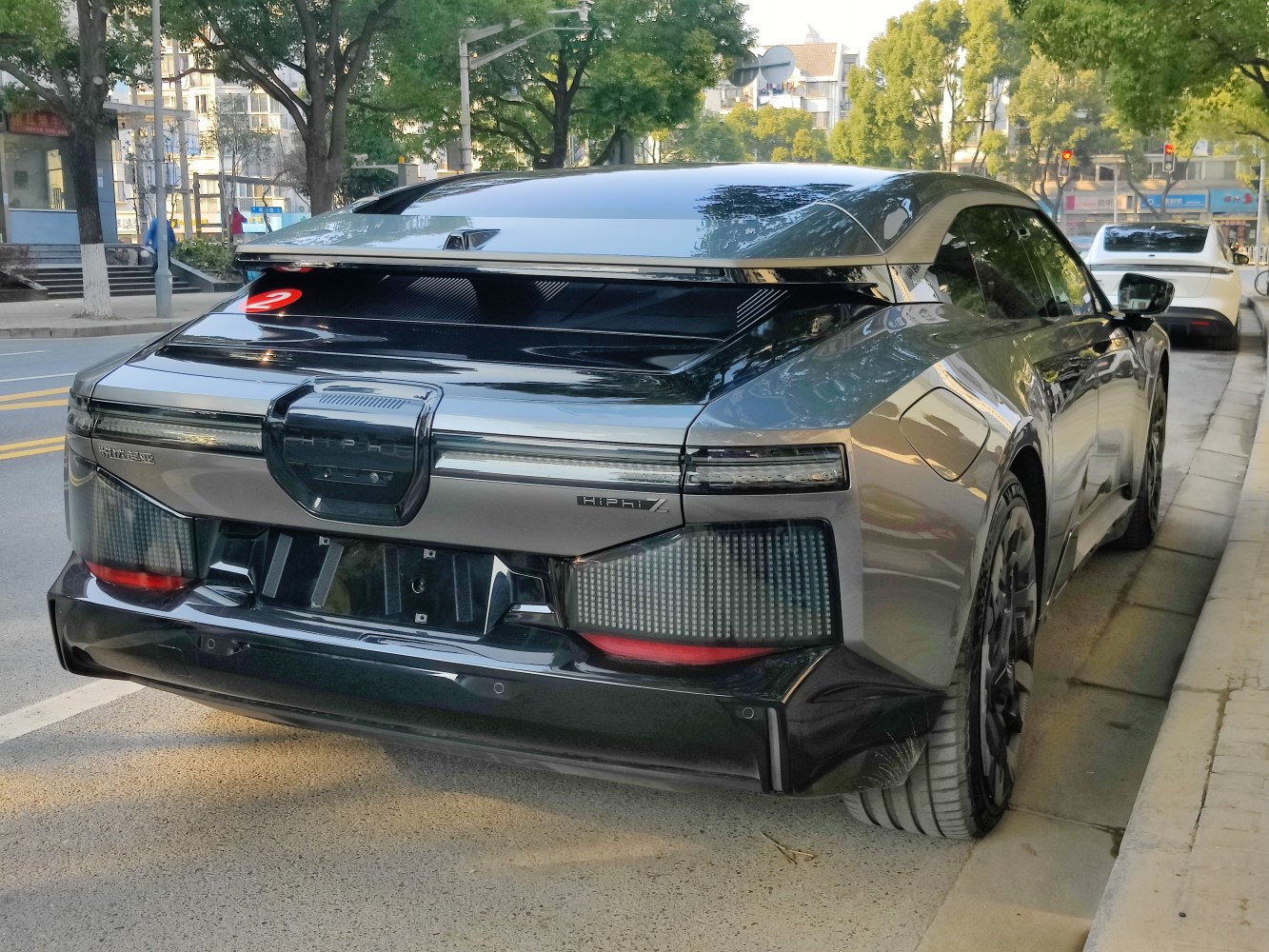 Rear view of futuristic electric sedan with LED taillights and aerodynamic design