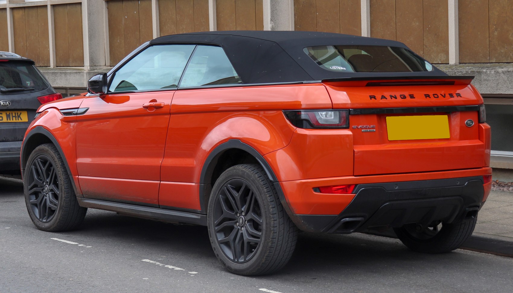 Rear side view of a convertible with black soft top and black alloy wheels