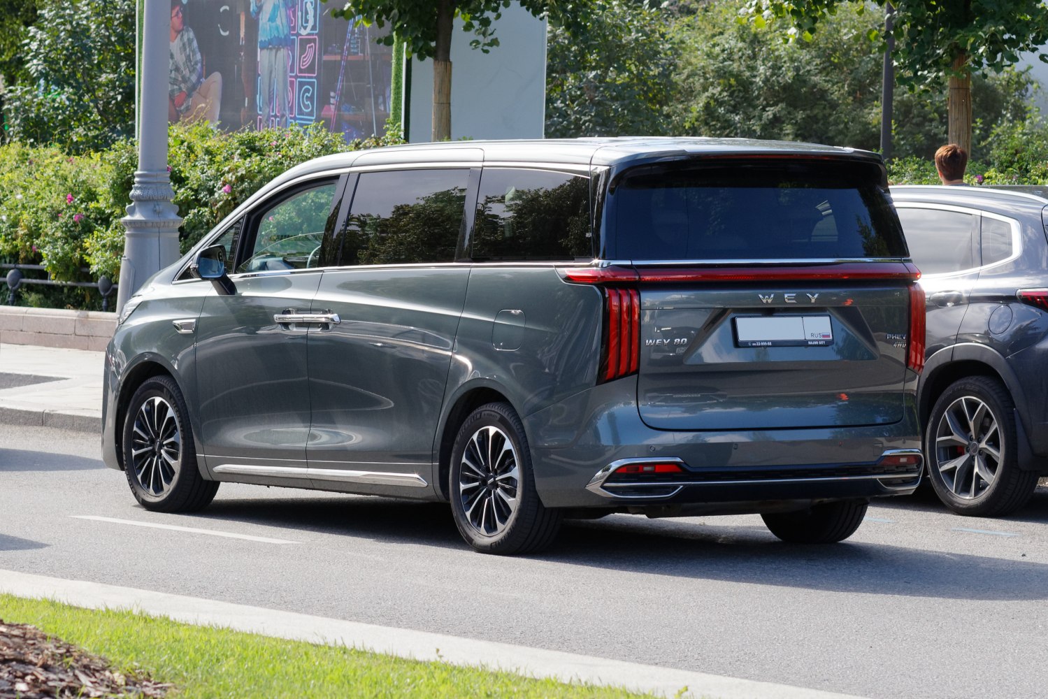 Rear and side view of a modern minivan with vertical tail lights.