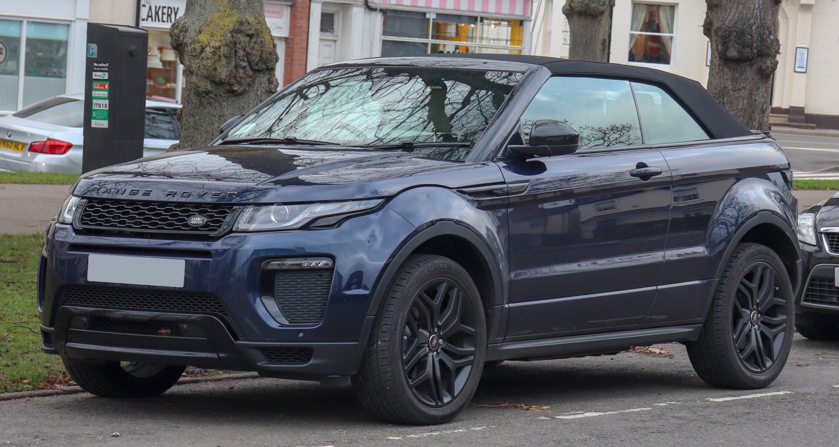 Front side view of convertible SUV with black soft-top roof and sleek wheels