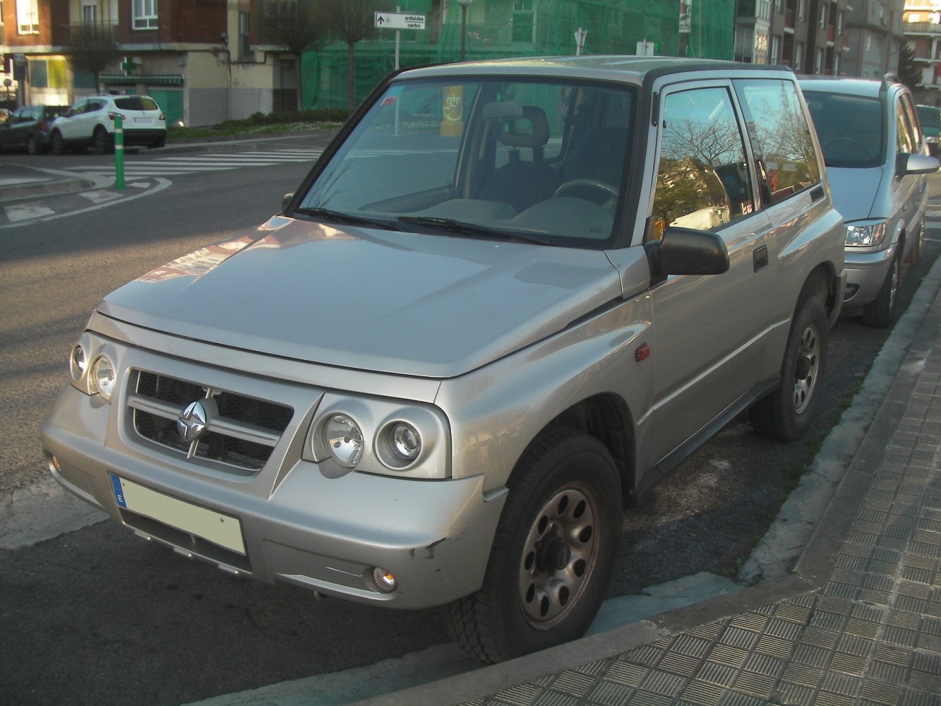 SUV with dual round headlights and boxy design parked on street