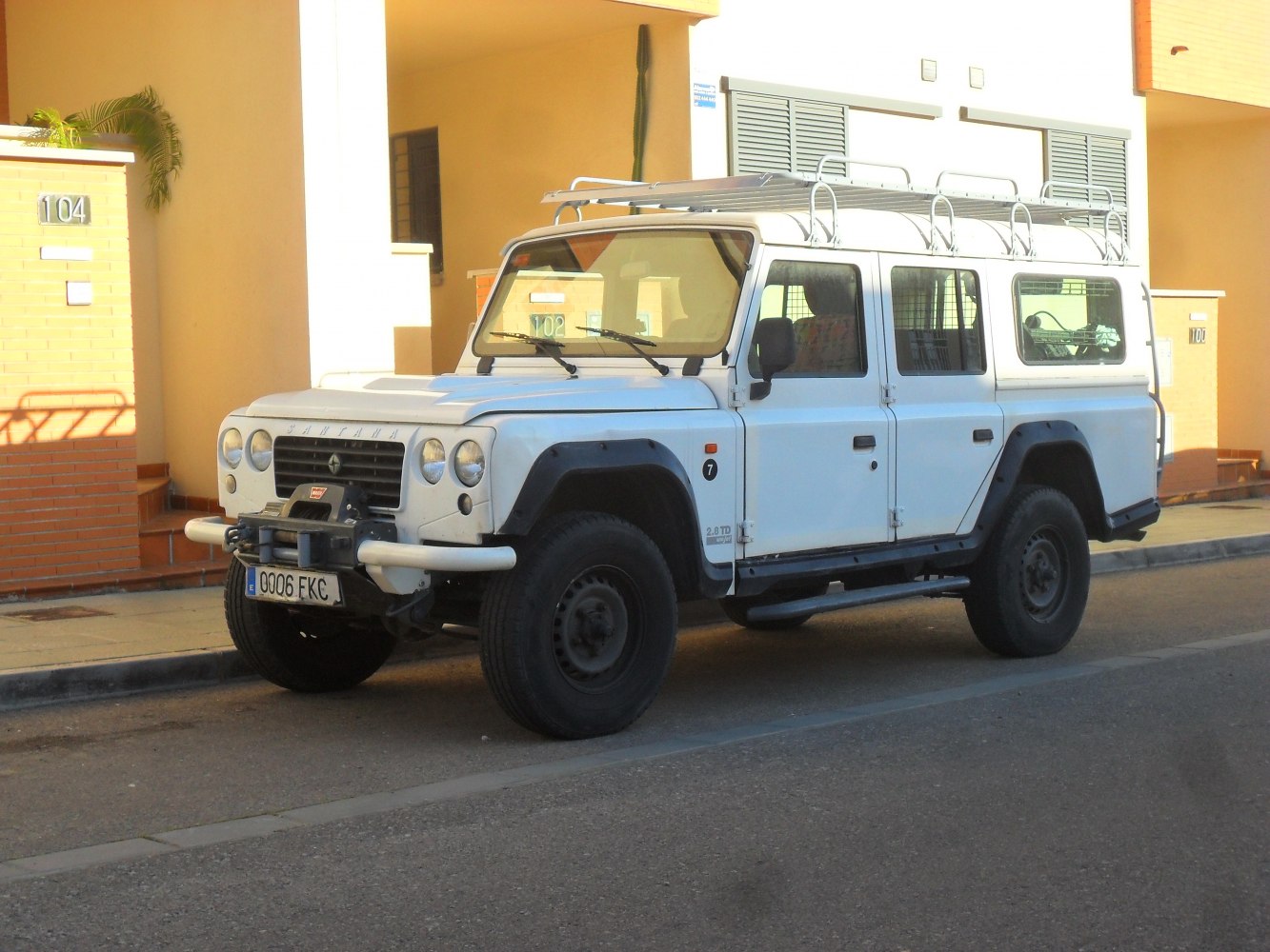 White 4x4 SUV with roof rack and offroad features