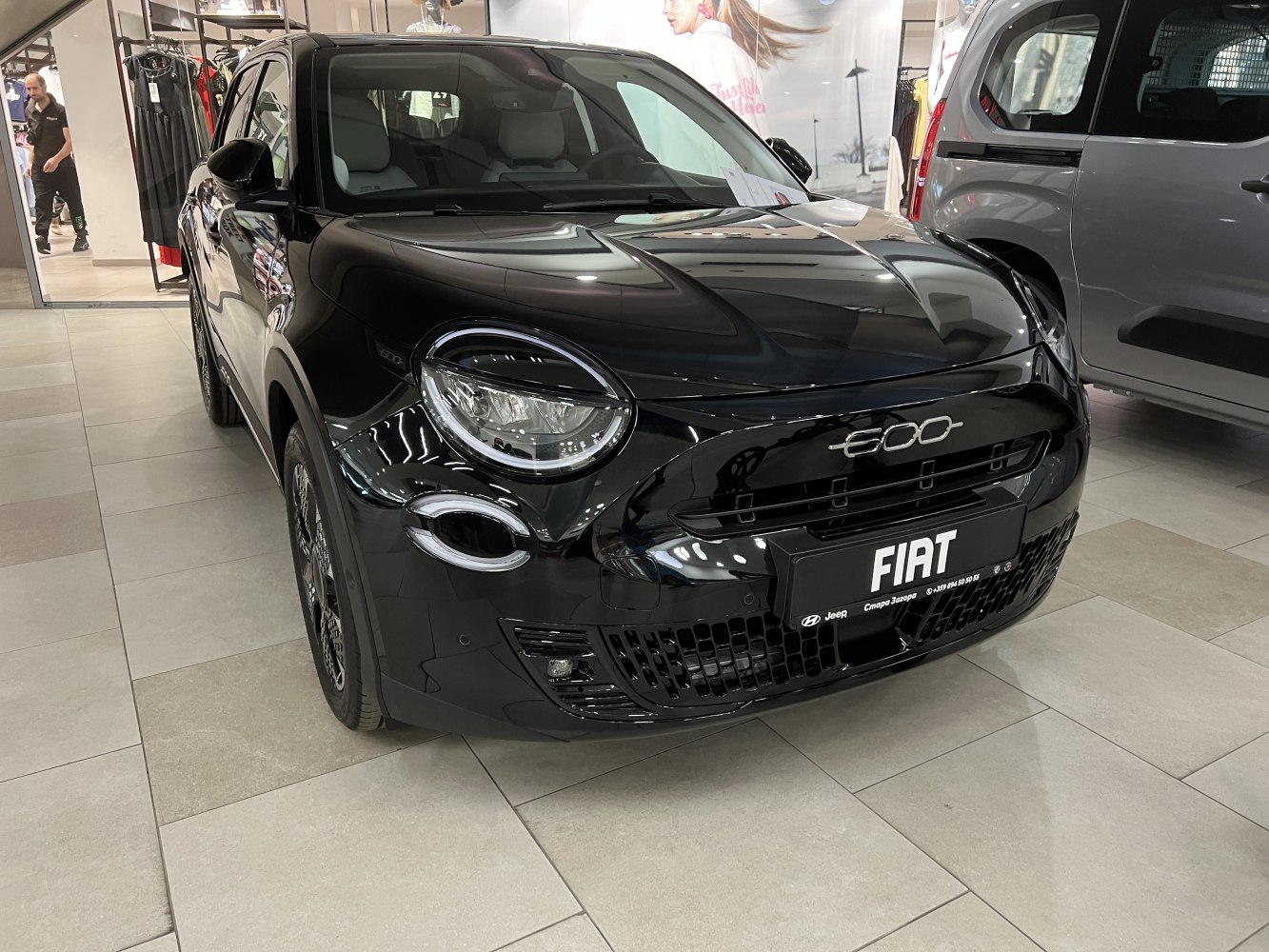 Compact car front with round headlights and black glossy finish