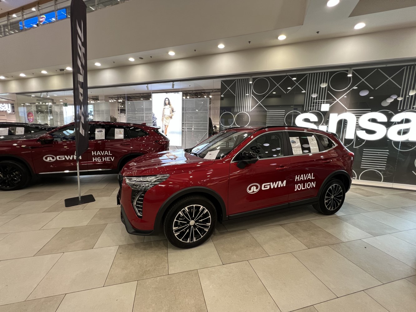 Front side view of a red SUV with alloy wheels in a showroom