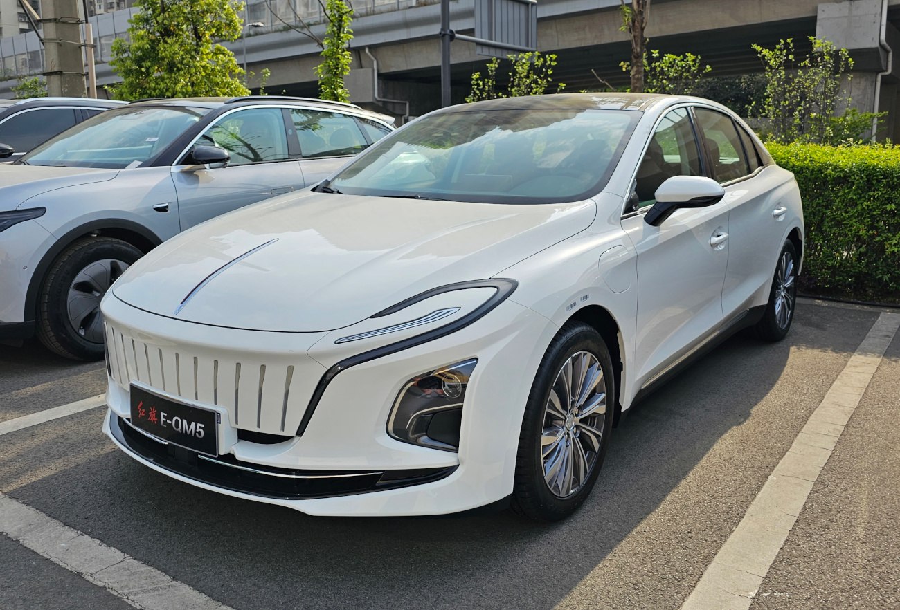 White electric sedan with vertical grille and LED headlights