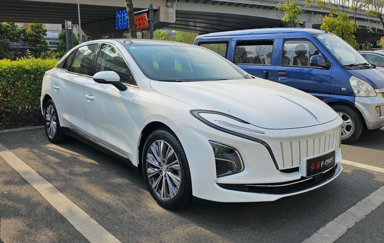 White electric sedan with slim LED lights and unique vertical grille