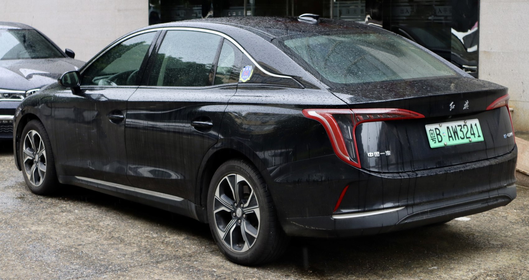 Rear and side view of black sedan with unique taillights and alloy wheels