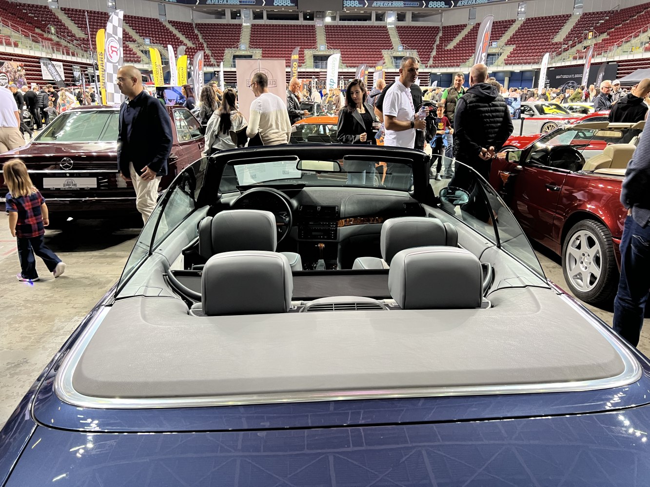 Convertible interior with leather seats and open roof at car exhibition