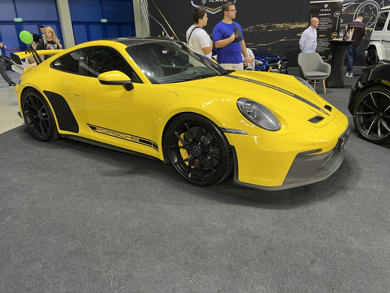 Yellow sports coupe with black racing decals and large rear spoiler