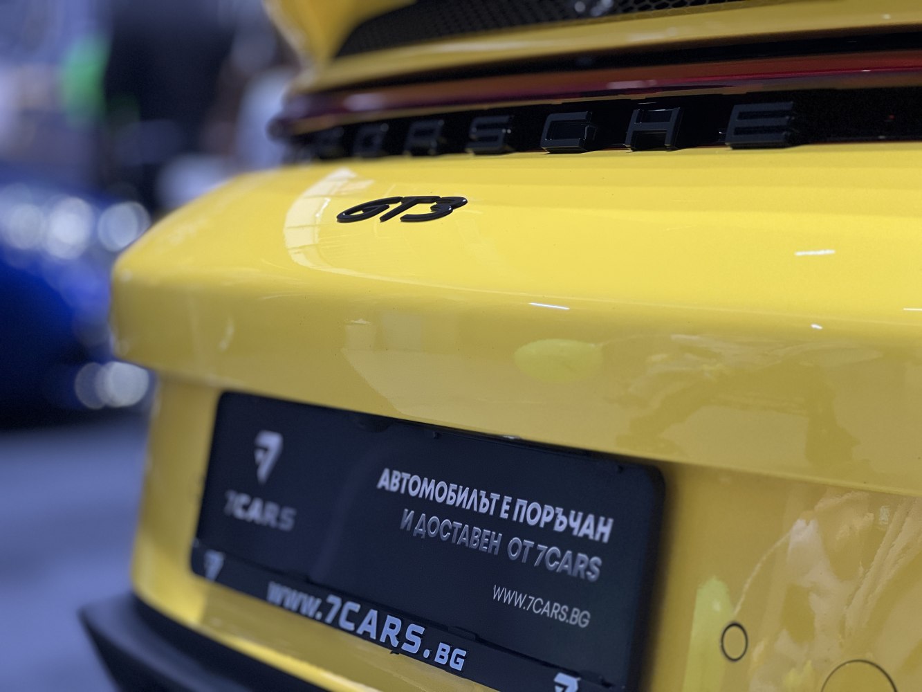 Close-up of yellow Porsche rear GT3 badge with license plate area