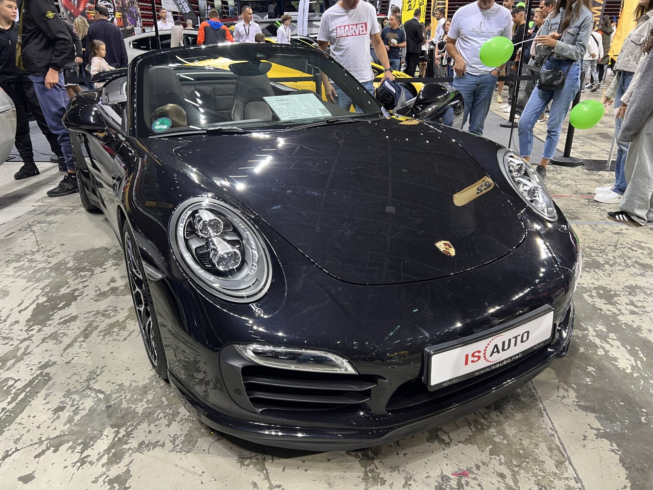 Front view of a black convertible with round LED headlights and sleek design