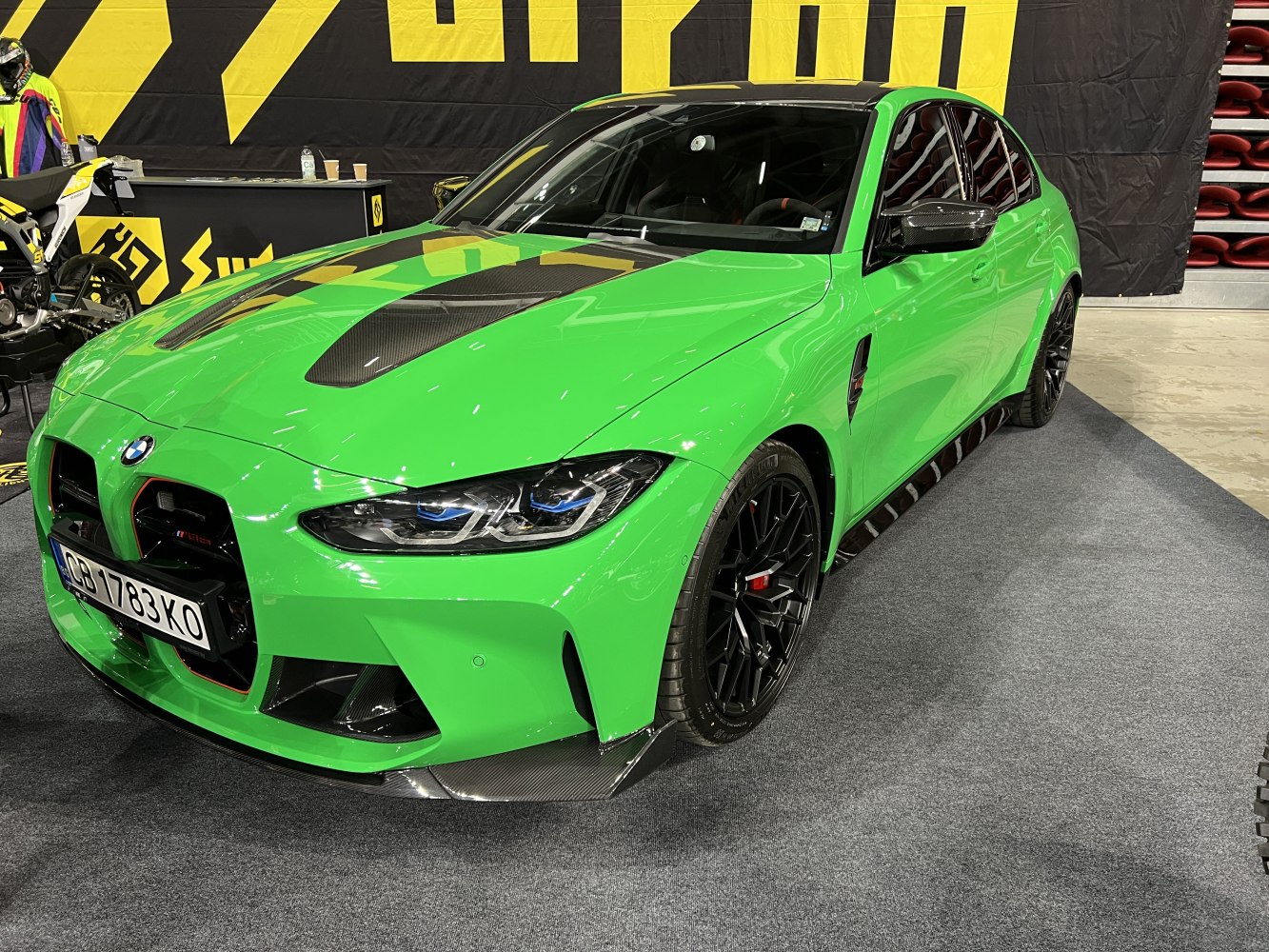 Green BMW M3 with carbon fiber hood and aggressive front splitter