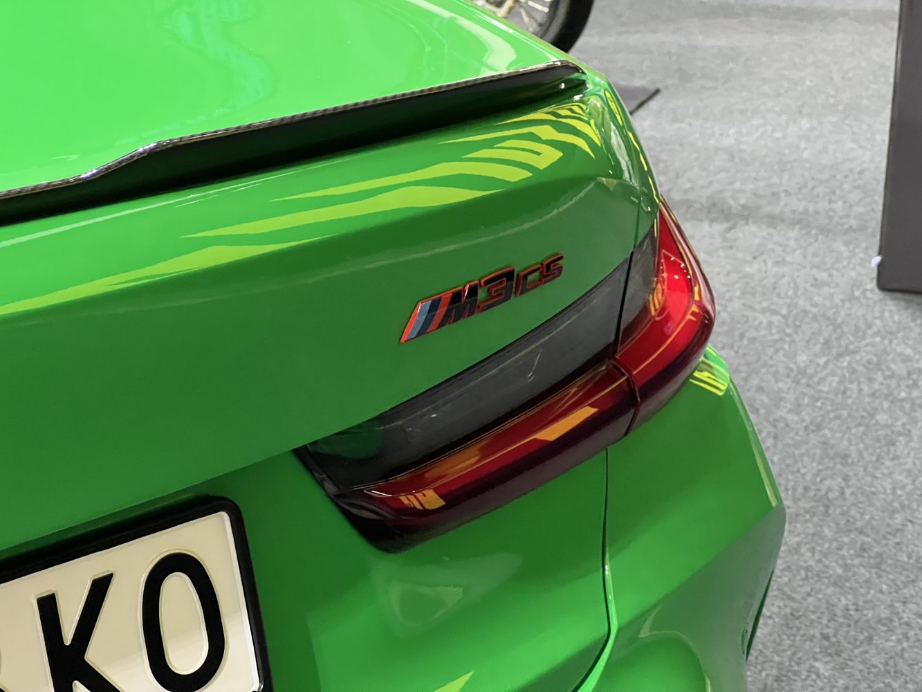Close-up of rear taillight with M3 CS badge on green car