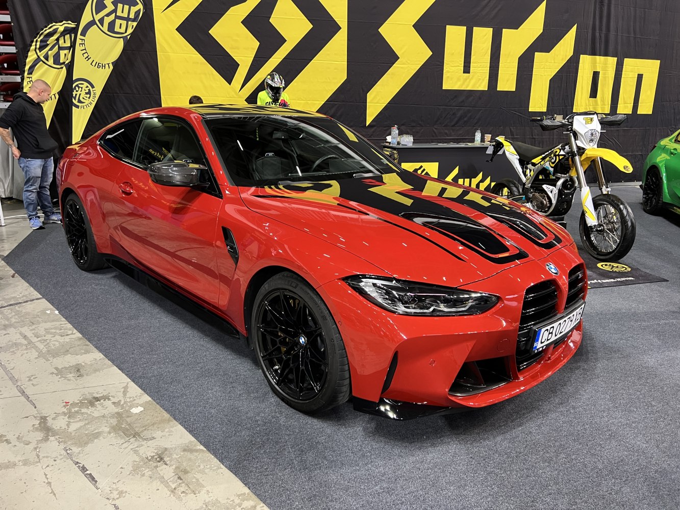 Red sports coupe with black hood vents and black rims