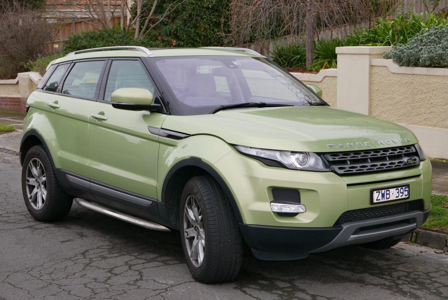 Front side view with sleek headlights, roof rails, and alloy wheels.