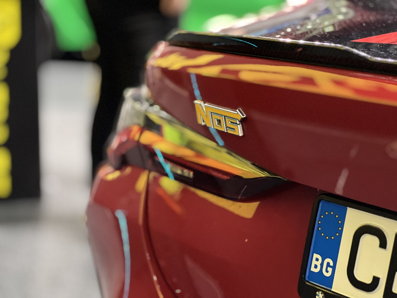 Close-up of a rear spoiler with NOS badge and license plate