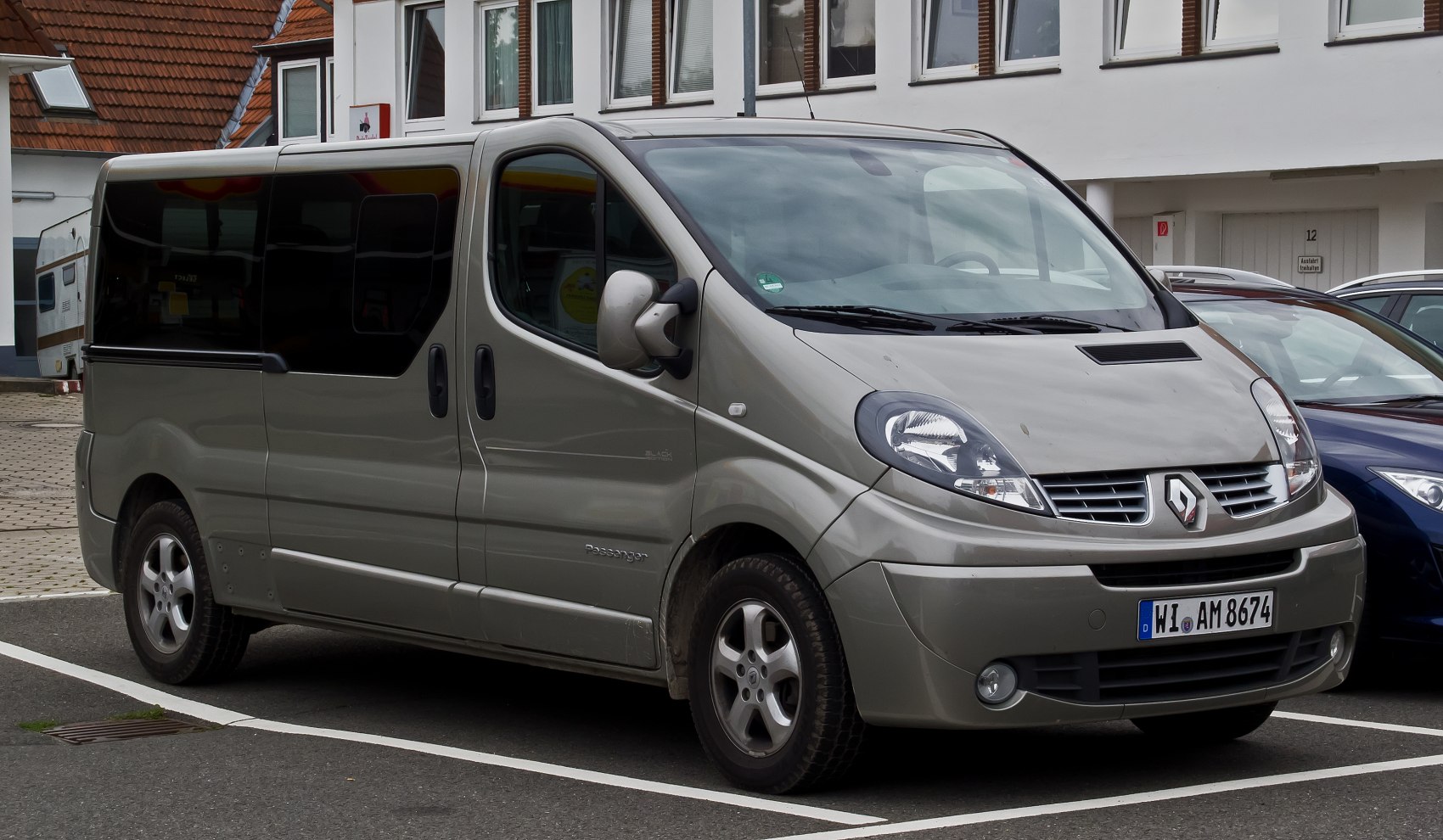 Silver passenger van with rounded headlights and large tinted side windows