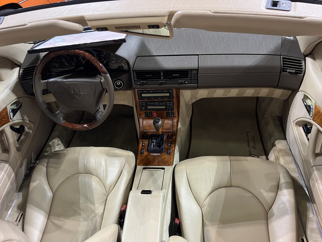 Wood trim dashboard and beige leather seats with classic automatic gear shift