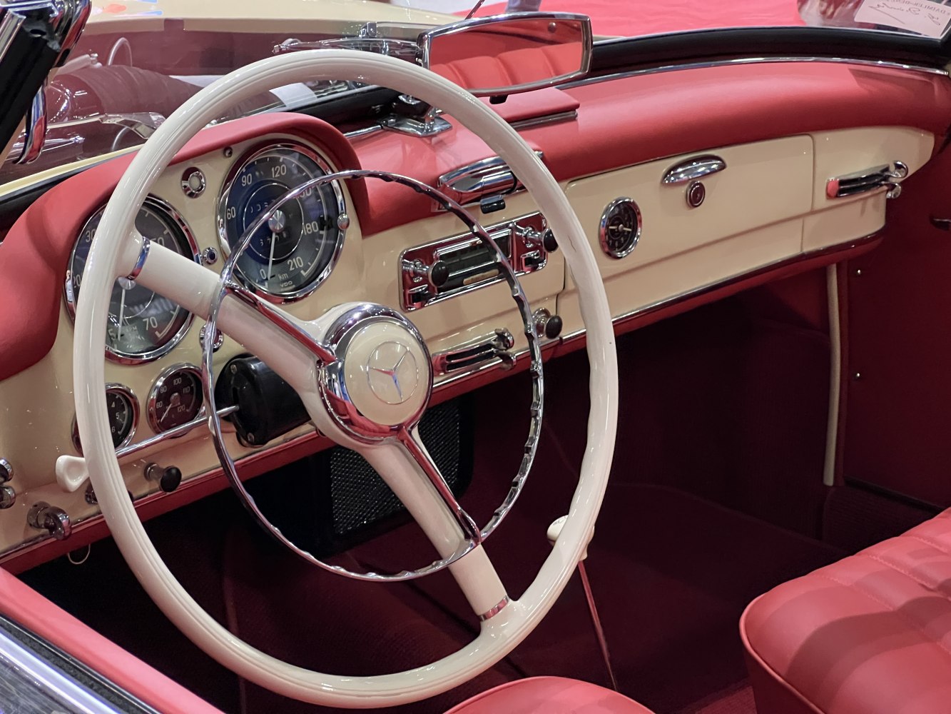Vintage car steering wheel with chrome ring and classic dashboard gauges
