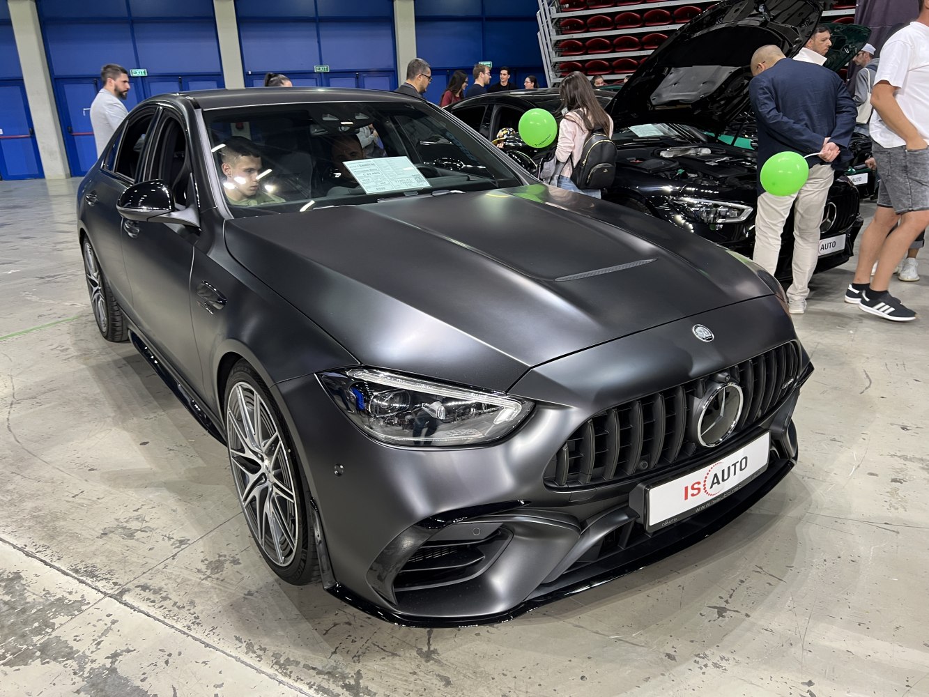 Matte black luxury sedan with aggressive grille and alloy wheels