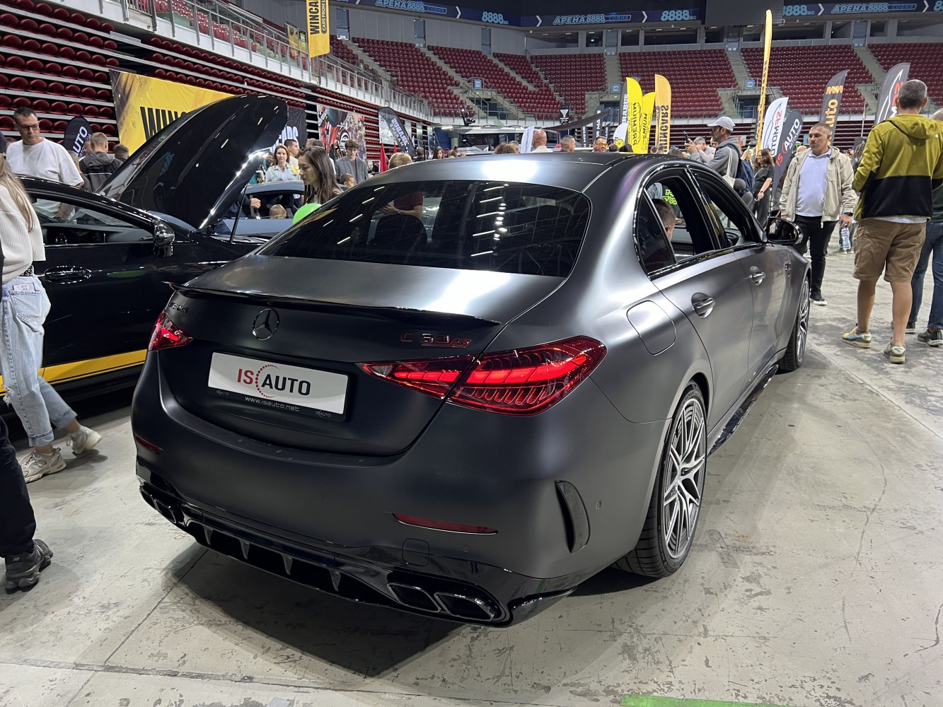 Matte black luxury sedan rear with LED tail lights and quad exhausts