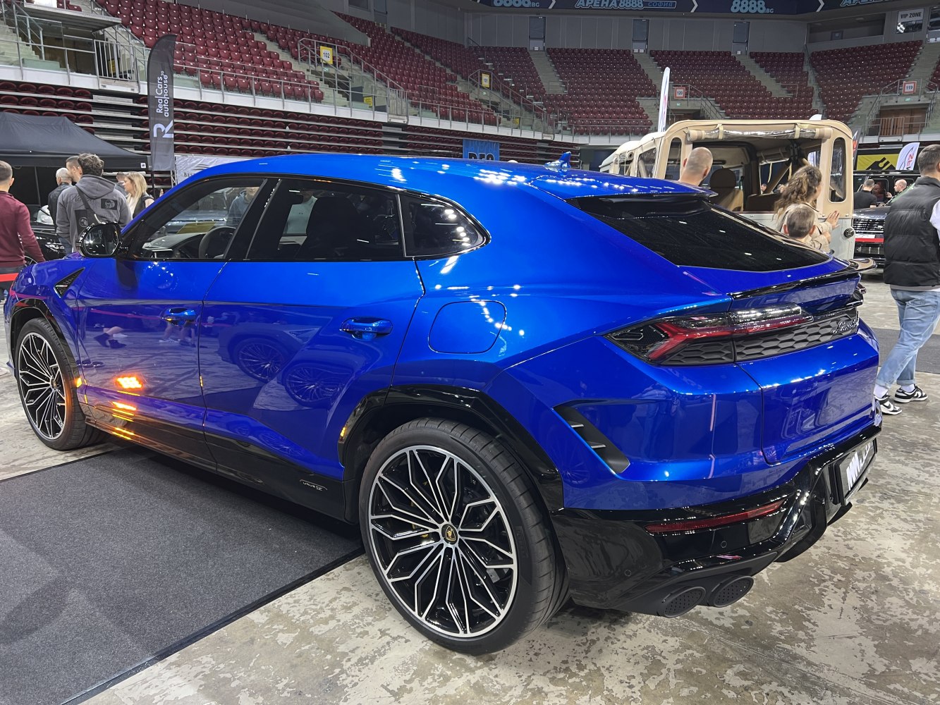 Rear and side profile of blue luxury SUV with multi-spoke wheels