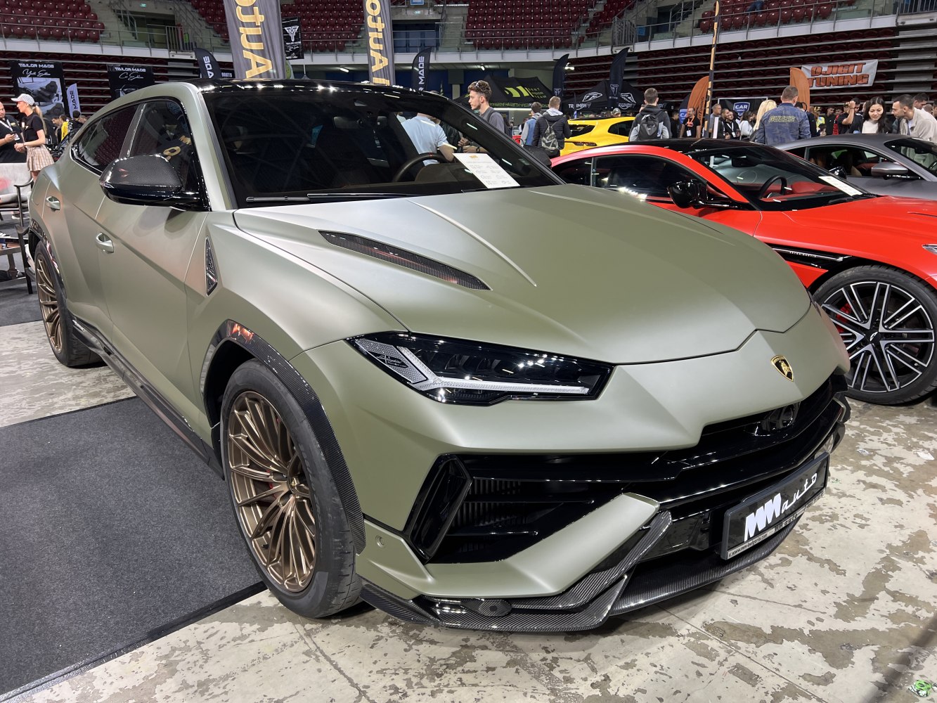 Matte green front view with bronze wheels and carbon fiber accents
