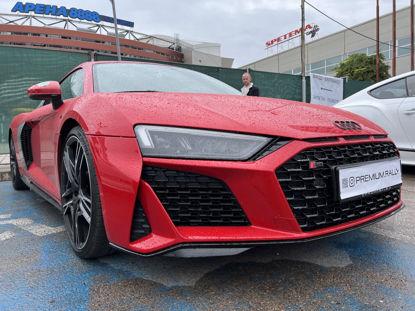 Close-up of red sports car front with LED headlights and aggressive grille