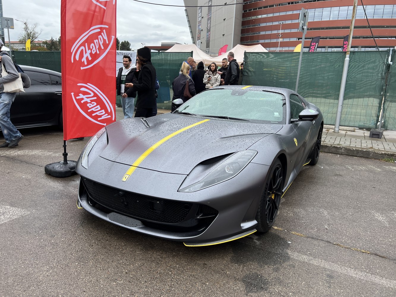 Front view of sleek sports car with yellow racing stripe on matte grey surface