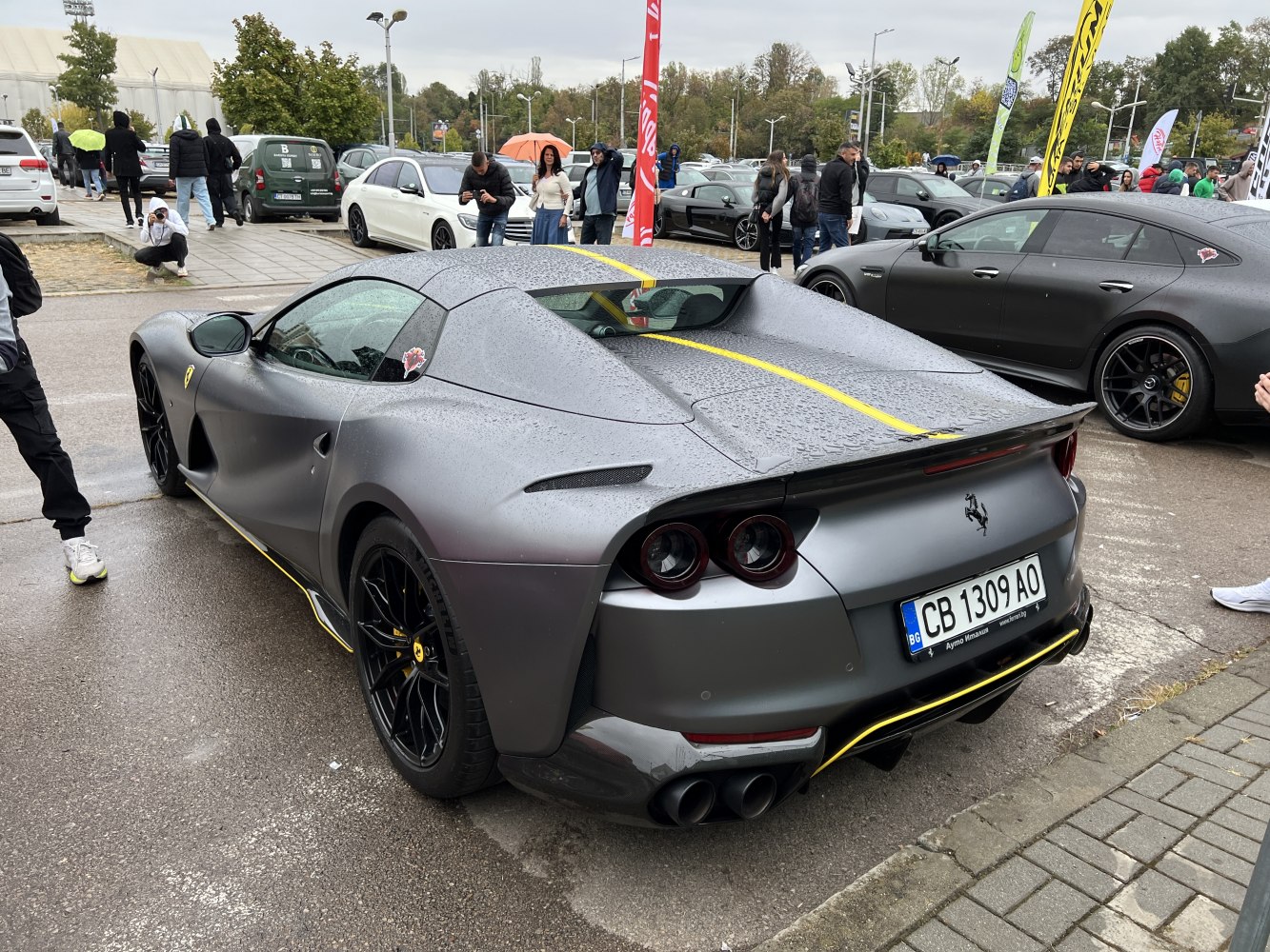 Rear view of matte silver sports car with yellow stripe and black wheels