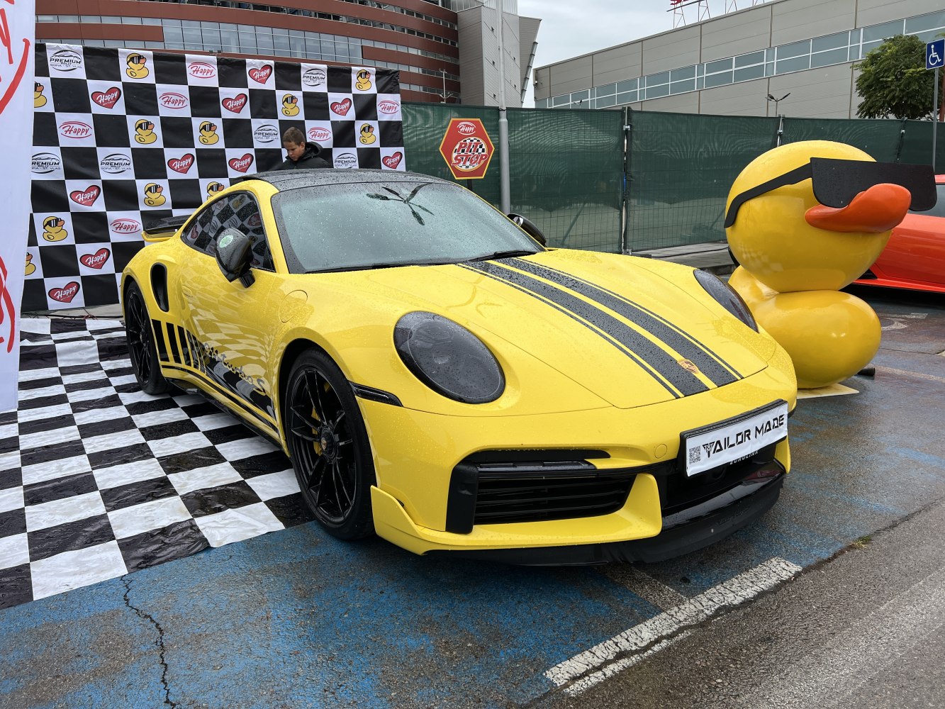 Yellow sports coupe with black racing stripes and black alloy wheels