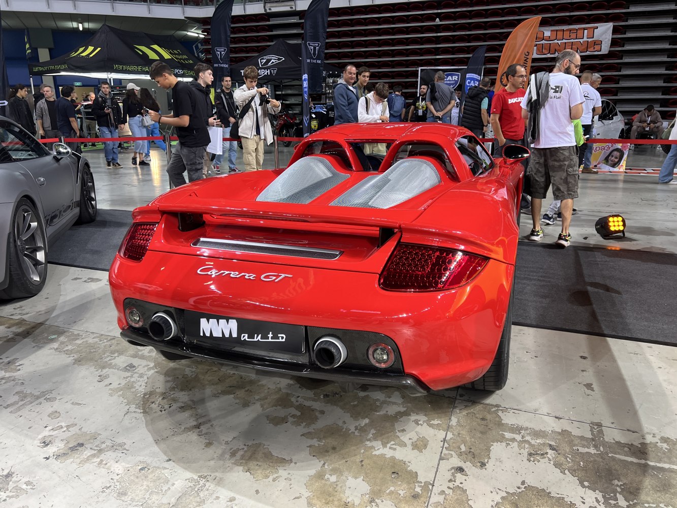 Rear view of a red sports car with dual exhaust and mesh engine covers