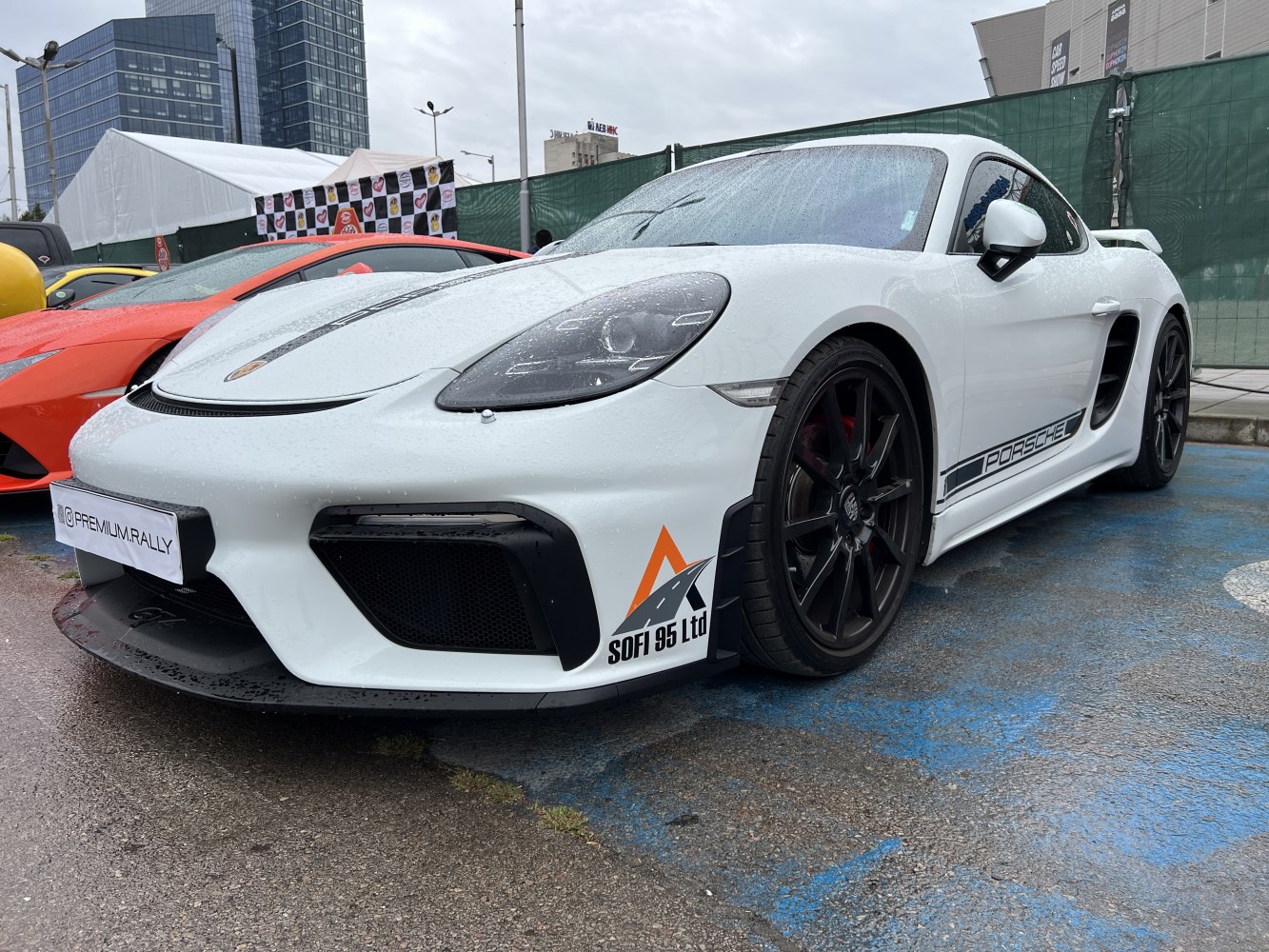 White Porsche 718 Cayman front side with black wheels and sporty air intakes