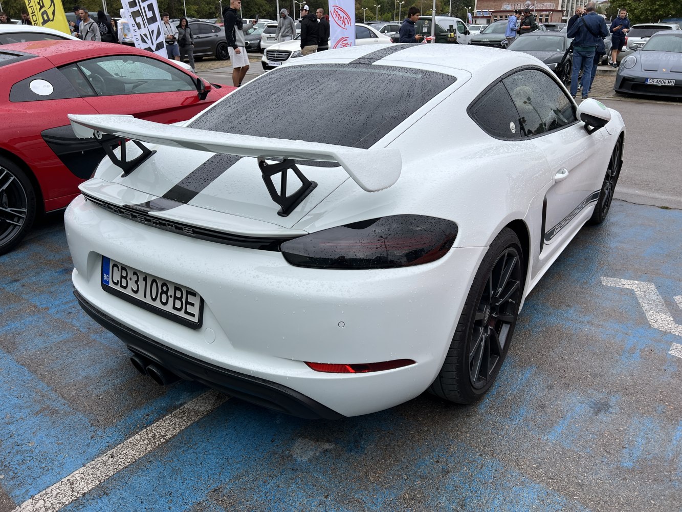 White sports coupe with large rear wing and black wheels